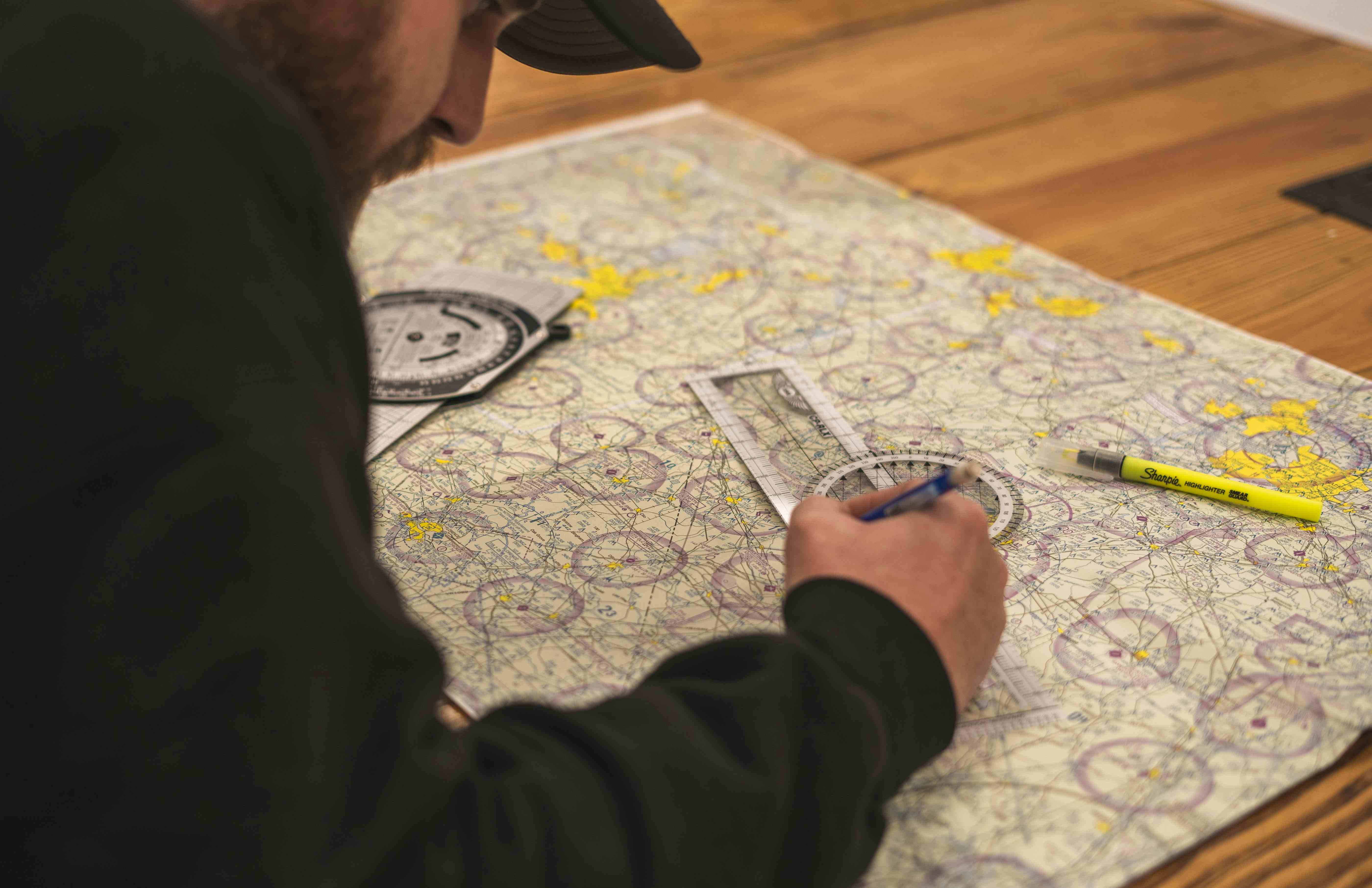 Student and instructor reviewing flight charts in a classroom setting.