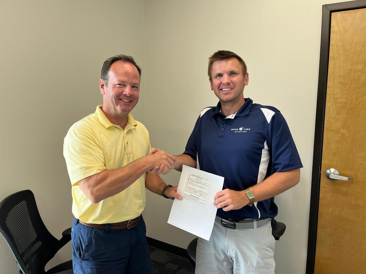 Student receiving a pilot certificate from an instructor at High Tide Aviation in Southport, NC.